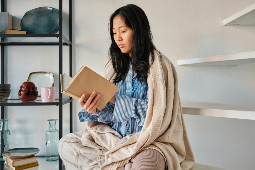 woman wrapped in blanket at home